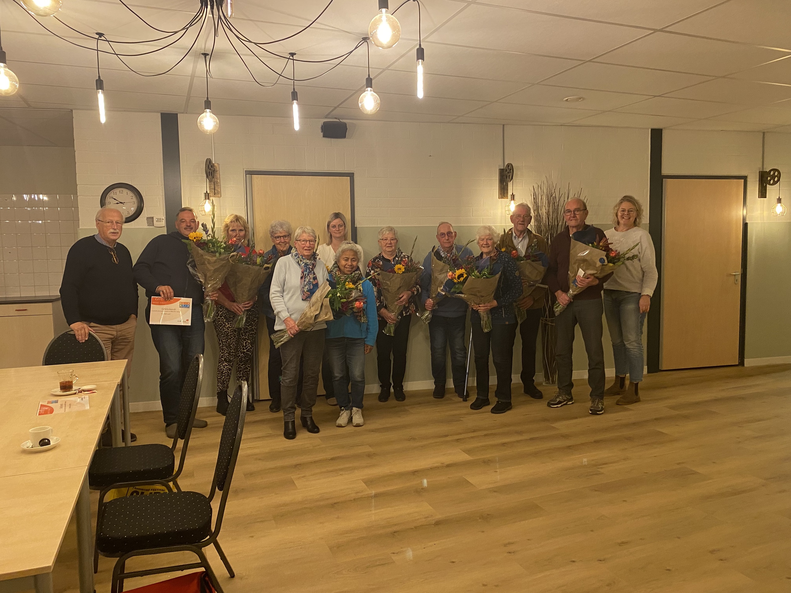 Foto van de wethouder met de deelnemers tijdens de uitreiking van het certificaat voor de computercursus in Hattem