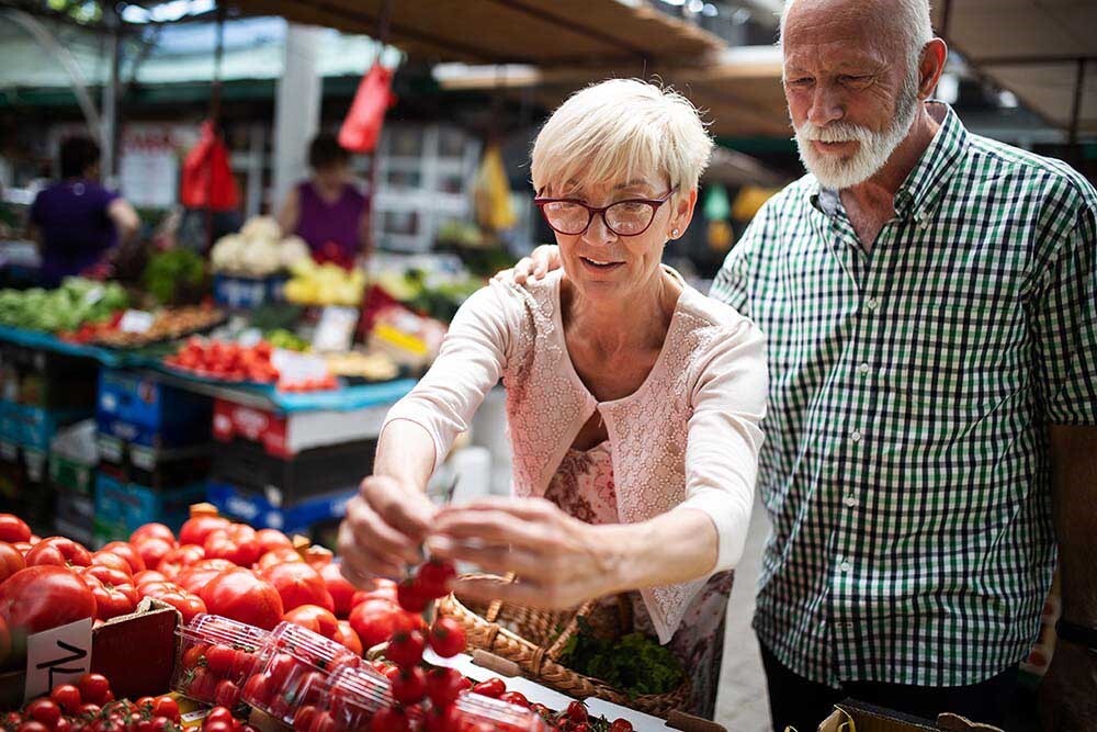 Foto van een oudere vrouw en een oudere man op de markt